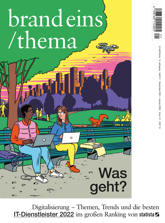 couple with laptop sitting on a bench in a park