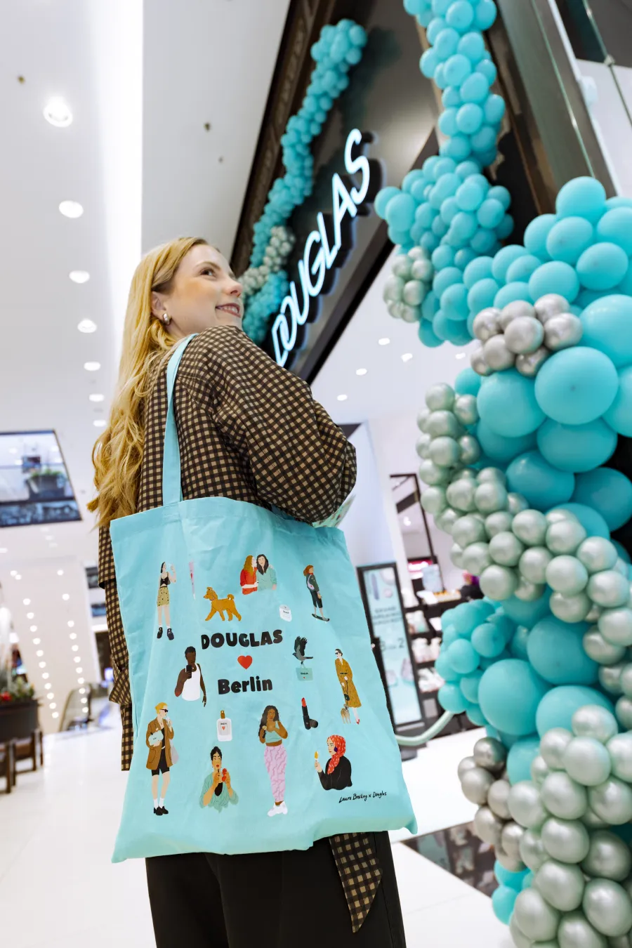 woman with printed bag in front of douglas store
