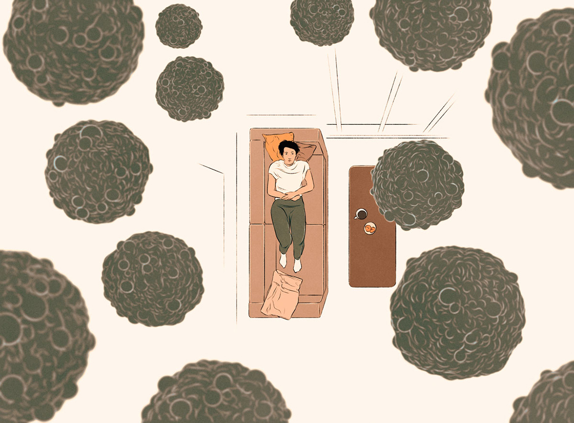 woman lying on a bed looking at cancer cells above her