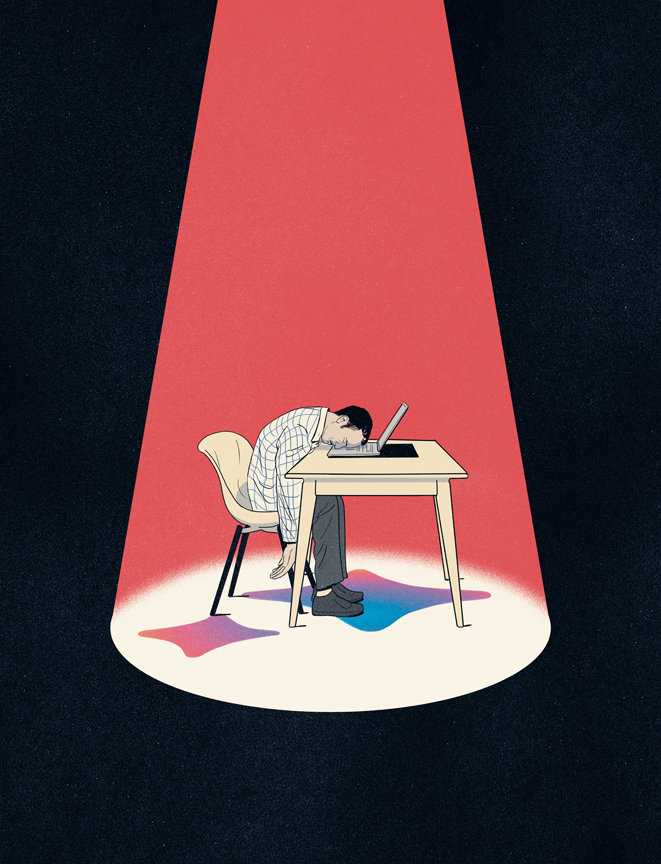 man sitting in a spotlight with head on his laptop